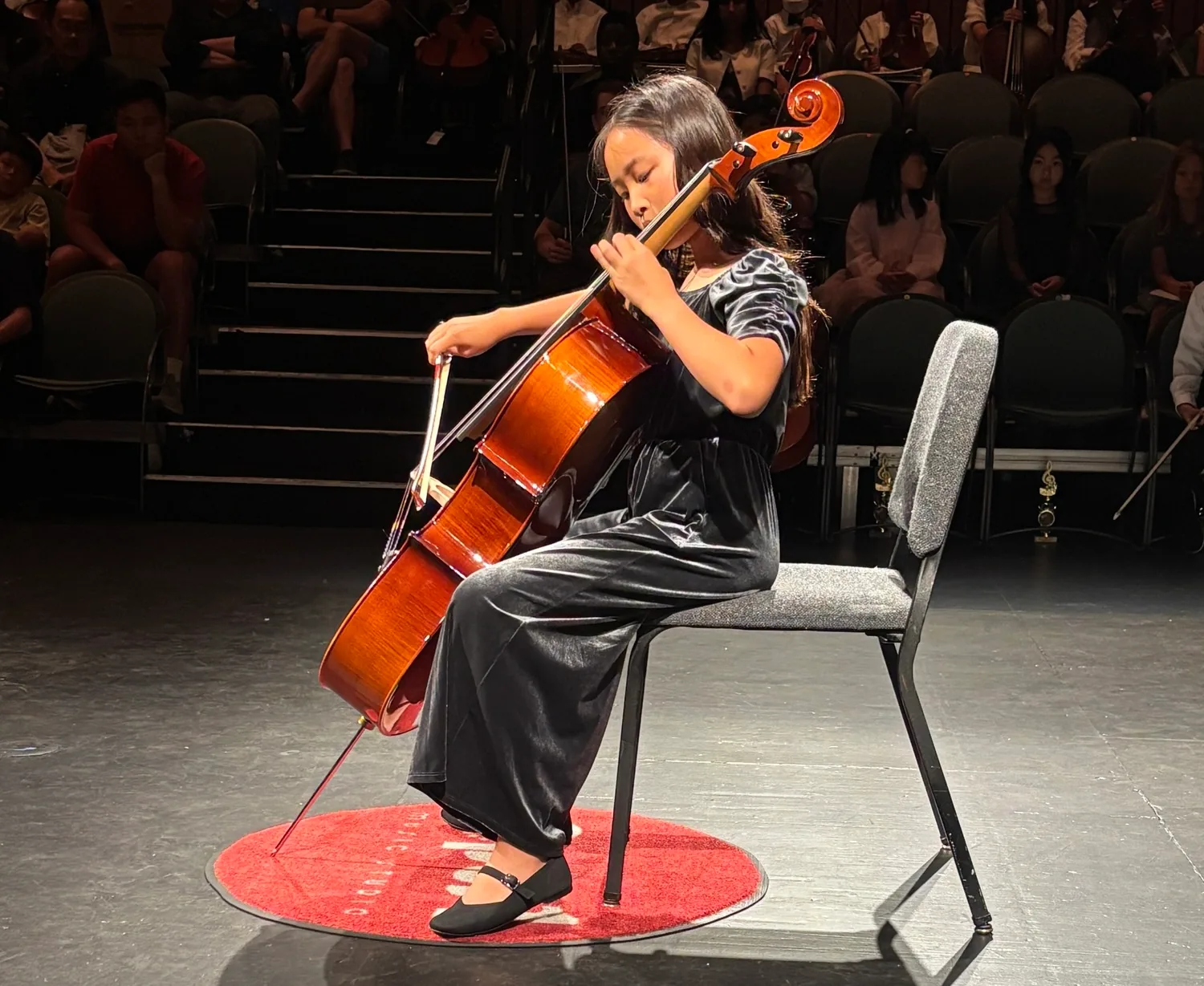 Young cellist performing on stage at an Opus 1 Music Studio recital
